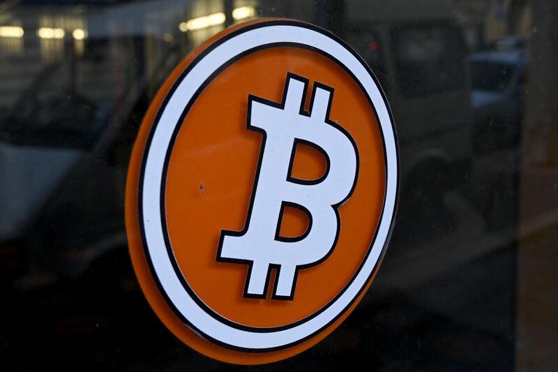 (FILES) This file photograph taken on January 8, 2021, shows a Bitcoin digital currency logo on the front door of an ATM in Marseille, southern France. Bitcoin's value plunged on May 19, 2021, after China signaled a new crackdown on the cryptocurrency, but its losses were cushioned after Tesla head Elon Musk spoke up on Twitter. The virtual currency fell to almost $30,000 -- less than half the record value it reached last month -- before climbing back over $39,500 around 2000 GMT. It was still above its level at the start of the year. Bitcoin recovered somewhat following tweets from Musk that featured a diamond and hands emoji, taken as a signal the company had not sold off its huge bitcoin holdings as the CEO appeared to suggest recently. / AFP / NICOLAS TUCAT
