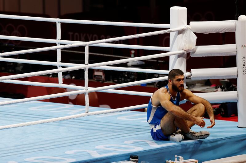 Mourad Aliev of France sits outside the ring in protest.