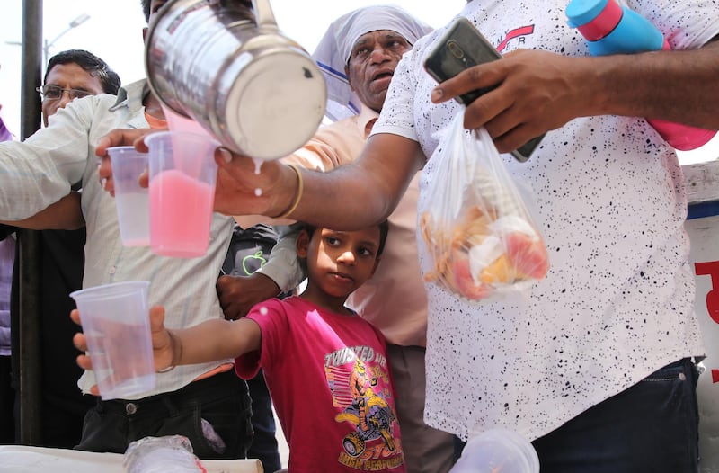 Volunteers offer sweet drinks to people in New Delhi, India. EPA