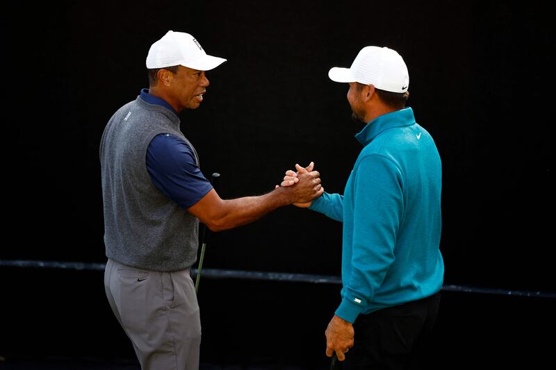 Tiger Woods and Jason Day greet each other on the putting green. AFP