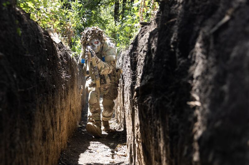 A Ukrainian soldier demonstrates tactical movements inside a trench in Luhansk Oblast, Ukraine. Anadolu Agency / Getty Images