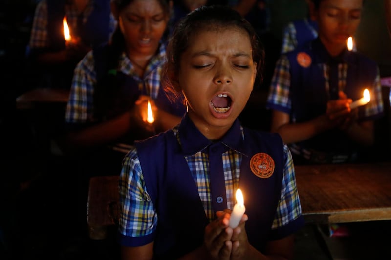 Indian students hold candles and pray for boys and their soccer coach who have been trapped since June 23, in Mae Sai, Chiang Rai province, northern Thailand, at a school in Ahmadabad, India, Monday, July 9, 2018. (AP Photo/Ajit Solanki)