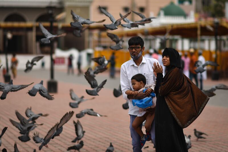 A Muslim family watches pigeons fly after Eid prayers at a Mosque in Chennai, India.