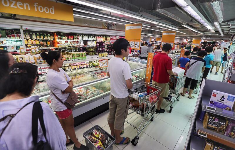 People queue for groceries at a supermarket in Singapore. AFP