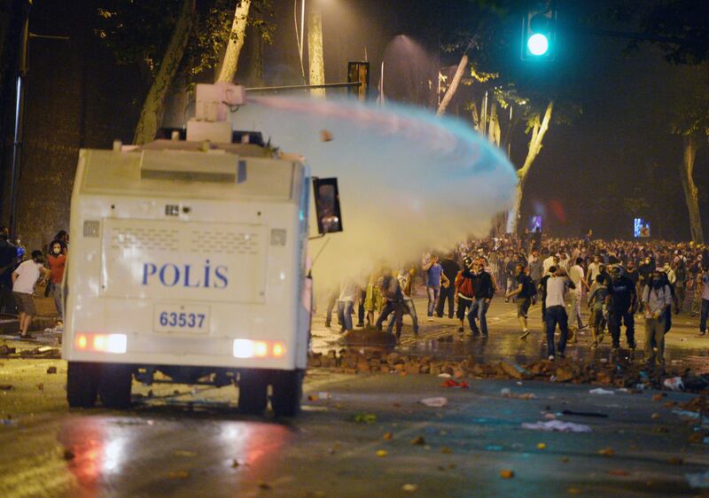 Turkish protesters clash with riot police near the former Ottoman palace, Dolmabahce, where Turkey's Prime Minister Recep Tayyip Erdogan maintains an office in Istanbul, Turkey, late Saturday, June 1, 2013. Turkish police retreated from a main Istanbul square Saturday, removing barricades and allowing in thousands of protesters in a move to calm tensions after furious anti-government protests turned the city center into a battlefield. A second day of national protests over a  violent police raid of an anti-development sit-in in Taksim square has revealed the depths of anger against Prime Minister Recep Tayyip Erdogan, who many Turks view as increasingly authoritarian and dismissive of opposing views.(AP Photo)