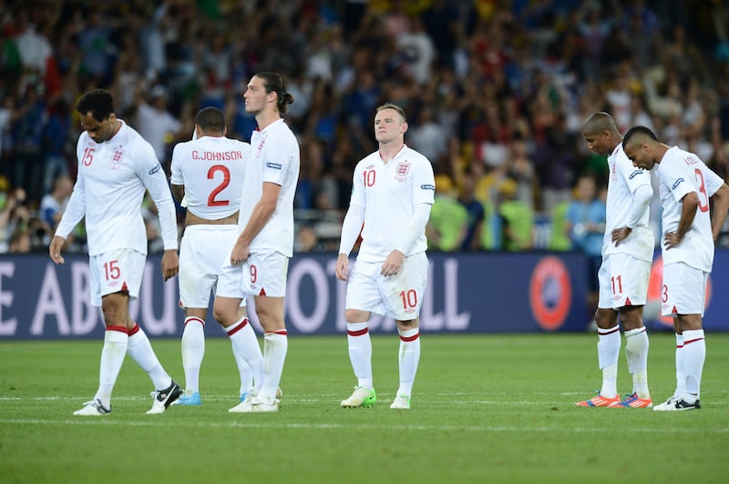 English forward Wayne Rooney (C) and teammates react after being defeated during the Euro 2012 football championships quarter-final match England vs Italy on June 24, 2012 at the Olympic Stadium in Kiev.  AFP PHOTO / CARL DE SOUZA / AFP PHOTO / CARL DE SOUZA