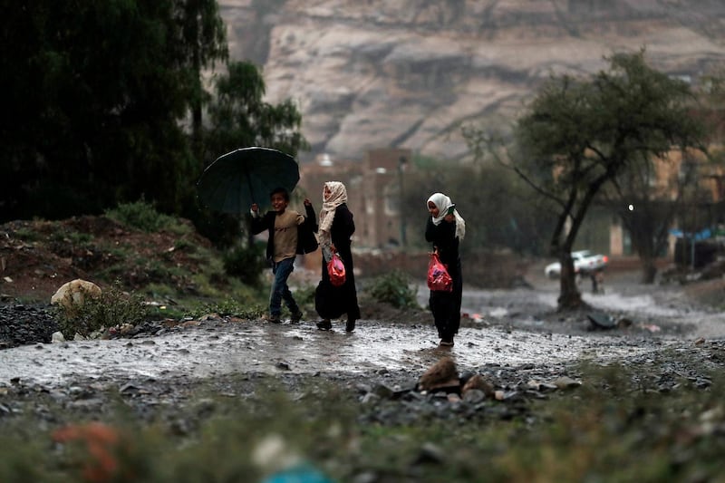 Yemeni children walk under the rain in Sana'a, Yemen.  EPA