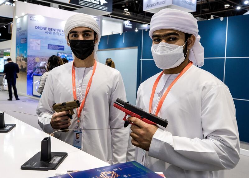 Abu Dhabi, United Arab Emirates, February 21, 2021.  Idex 2021, the first major in-person exhibition held in Abu Dhabi since the start of the Covid-19 pandemic, opened its doors to delegates on Sunday morning.  --Omar Al Matrooshi and Rashed Al Raess looks at a GLOCK 9mm. pistols.
Victor Besa / The National
Section:  NA
Reporter:  John Dennehy