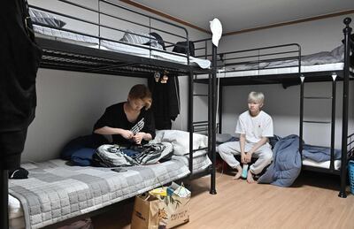 This picture taken on April 29, 2021 shows K-pop boy band Blitzers members Jang Jun-ho (L) and Lee Jun-young (R) sitting on bunk-beds after waking up in the band's shared house in Seoul. Thirty teenagers, thousands of hours of training, dozens of shattered dreams: it all comes to a head next week when the Blitzers will be launched into the cut-throat K-pop market, hoping to become the next BTS. - TO GO WITH SKorea-music-social-entertainment-Kpop,FOCUS by Kang Jin-kyu
 / AFP / Jung Yeon-je / TO GO WITH SKorea-music-social-entertainment-Kpop,FOCUS by Kang Jin-kyu
