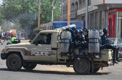 (FILES) In this file photo taken on February 24, 2021 Riot police officers patrol on a pick-up truck during clashes with demonstrators as opposition supporters protest after the announcement of the results of the country's presidential run-off in Niamey. Soldiers were arrested in Niger after an "attempted coup" early on March 31, a security source said, adding "the situation is under control." "There were some arrests among a few members of the army who are behind this attempted coup. The Presidential Guard retaliated, preventing this group of soldiers from approaching the presidential palace," said the source, speaking after residents reported hearing bursts of gunfire in the night in the capital Niamey. / AFP / Issouf SANOGO
