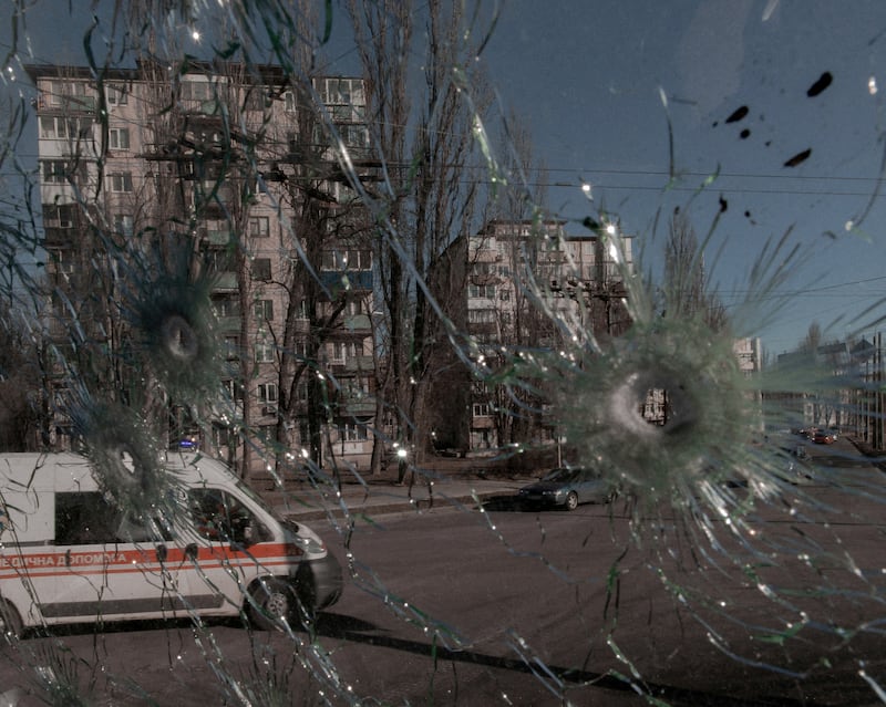 An ambulance is visible through the damaged window of a vehicle hit by bullets in Kiev, Ukraine. Reuters