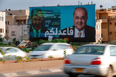 A picture taken on February 21, 2020, shows a portrait of Arab Israeli member of the Joint List Ahmad Tibi on a campaign poster, with Arabic writing stating, "I am staying seated for you" in the northern Israeli City of Tayyiba. AFP