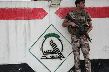 A fighter belonging to Iraq's PMF paramilitary forces stands guard at the group's headquarters in Baghdad. AFP 