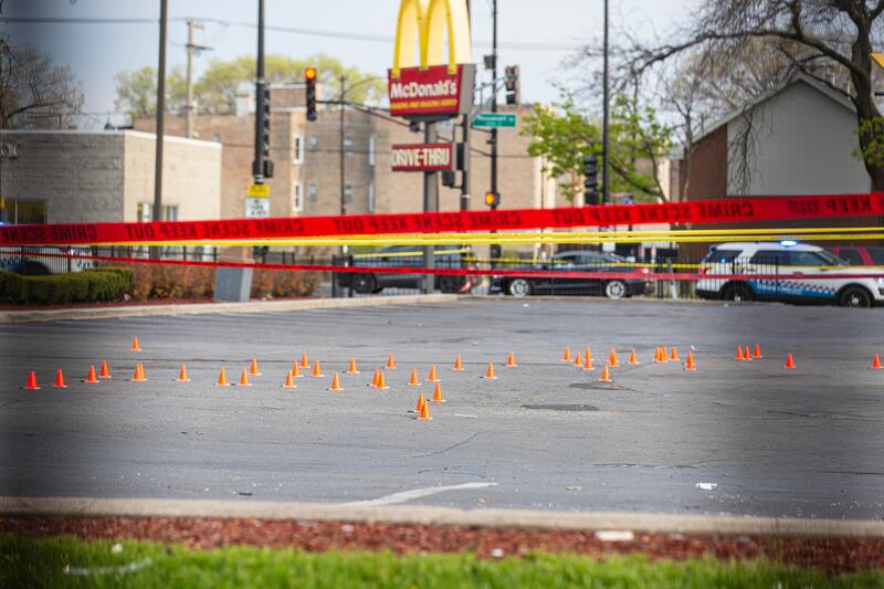 Markers identify bullet casings as police investigate the scene where Jontae Adams, 28, and his daughter Jaslyn, 7, where shot in Chicago. AP