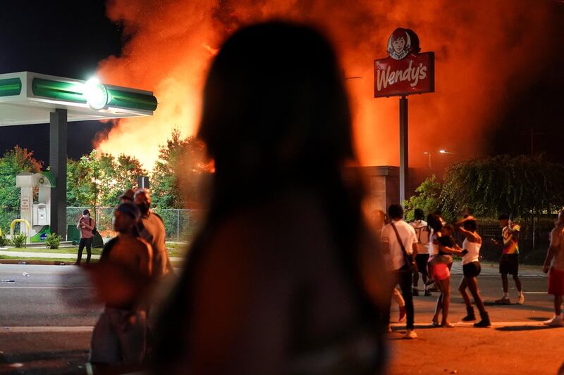 People watch as a Wendy’s restaurant burns following a rally against racial inequality and the police shooting death of Rayshard Brooks, in Atlanta, Georgia. Reuters