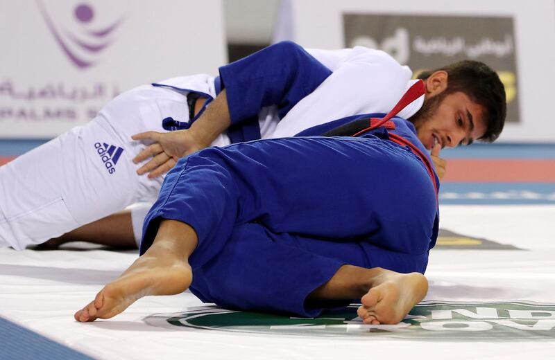 ABU DHABI , UNITED ARAB EMIRATES, September 29 , 2018 :- Mohammad Abdolreza ( white ) of Sharjah Jiu-Jitsu Club and Mohammed Al Qubaisi ( blue ) of Team 777 during the 85kg seniors category game in the Jiu-Jitsu President’s Cup Round -1 held at Al Jazira Club Indoor stadium in Abu Dhabi. Mohammad Abdolreza won the game. ( Pawan Singh / The National )  For Sports. Story by Amith