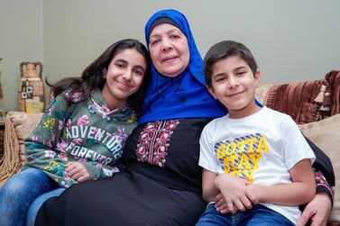 Samiha Ahmed, who is in recovery from lung cancer, pictured at home in Abu Dhabi with grandchildren Tasneem, 11 and Marwan, 8. Victor Besa / The National