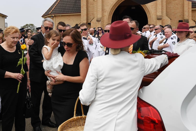 Melissa and Charlotte O'Dwyer, the wife and young daughter of Rural Fire Service volunteer Andrew O'Dwyer, farewell their husband and father during the funeral at Our Lady of Victories Catholic Church in Horsley Park, Sydney. Getty Images
