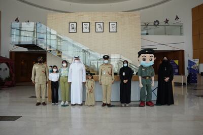 Hoor Hadad poses in her police uniform with the officers who surprised her for her birthday and police mascot Mansour. Photo: Dubai Police