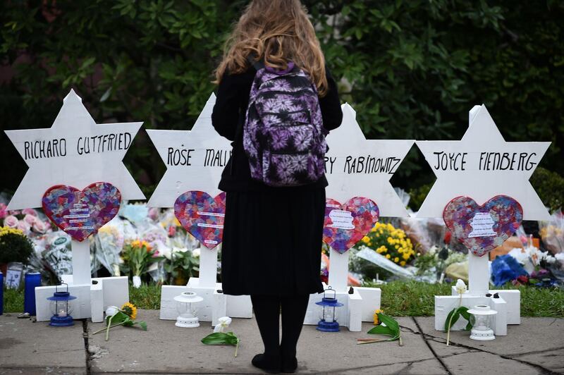 TOPSHOT - A woman stands at a memorial outside the Tree of Life synagogue after a shooting there left 11 people dead in the Squirrel Hill neighborhood of Pittsburgh on October 27. Mourners held an emotional vigil Sunday for victims of a fatal shooting at a Pittsburgh synagogue, an assault that saw a gunman who said he "wanted all Jews to die" open fire on a mostly elderly group. Americans had earlier learned the identities of the 11 people killed in the brutal assault at the Tree of Life synagogue, including 97-year-old Rose Mallinger and couple Sylvan and Bernice Simon, both in their 80s.Nine of the victims were 65 or older.

 / AFP / Brendan SMIALOWSKI
