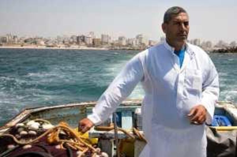 Skipper of a fishing boat Naheth Abu Ameera, 49, navigates his fishing boat out of Gaza City port. *** Local Caption ***  GazanFishermen049.jpg