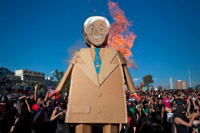 A dummy depicting Chilean President Sebastian Pinera burns during a protest against gender violence and patriarchy in Santiago.  AFP