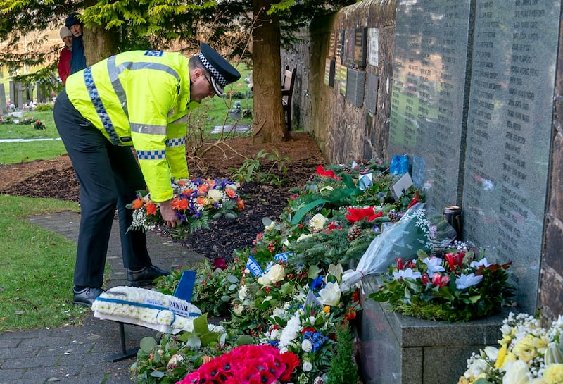 A representative from Police Scotland lays a wreath