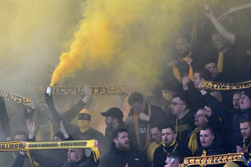 Dortmund fans hold up yellow flares before kick-off. AFP