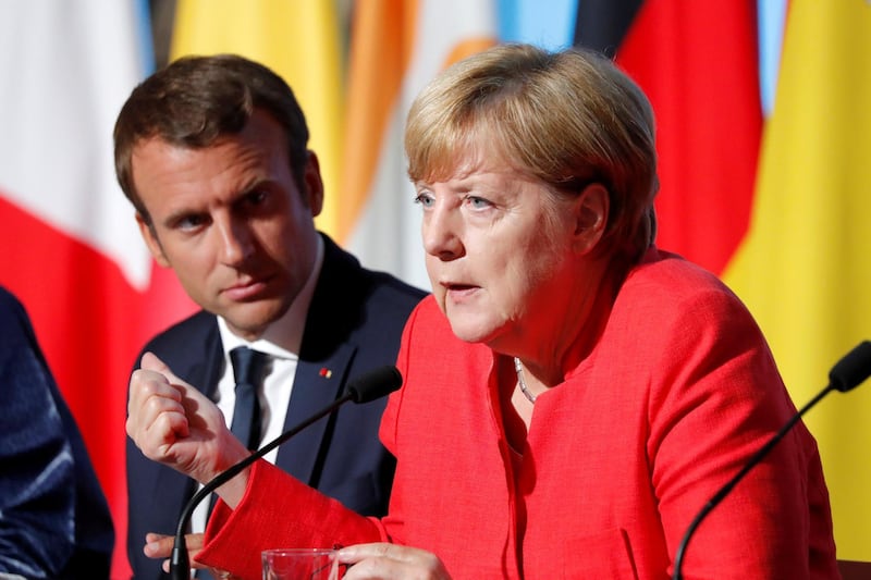 FILE PHOTO: French President Emmanuel Macron (L) and German Chancellor Angela Merkel attend a news conference following talks on European Union integration, defence and migration at the Elysee Palace in Paris, France August 28, 2017. REUTERS/Charles Platiau/File Photo