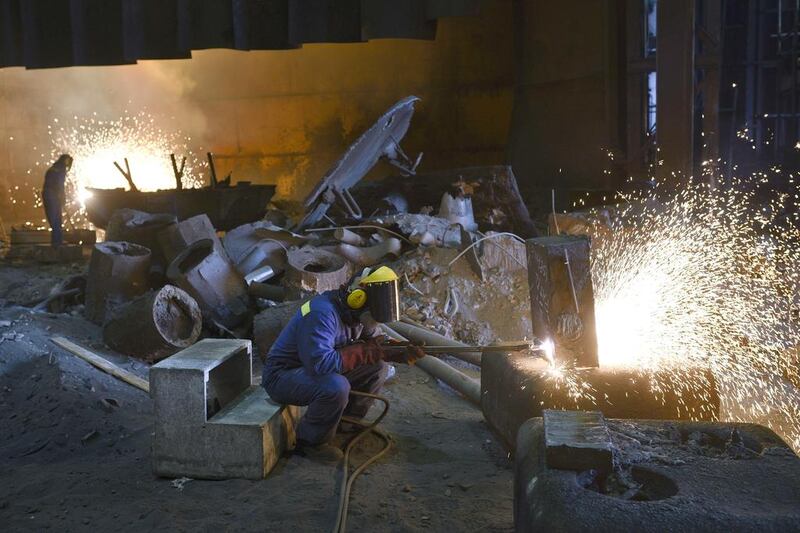 Burners work on freshly cast steel items as they work in the foundry. Oli Scarff / AFP