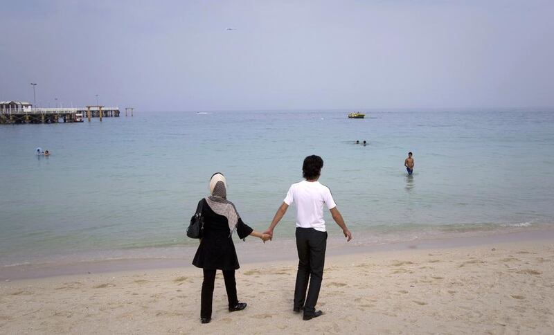 A couple walk on the beach at Kish Island. Reuters