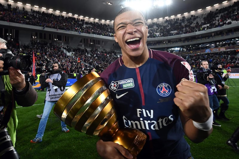 TOPSHOT - Paris Saint-Germain's French forward Kylian Mbappé holds the trophy as he celebrates after victory in the French League Cup final football match between Monaco (ASM) and Paris Saint-Germain (PSG) at The Matmut Atlantique Stadium in Bordeaux, southwestern France on March 31, 2018.  / AFP PHOTO / FRANCK FIFE
