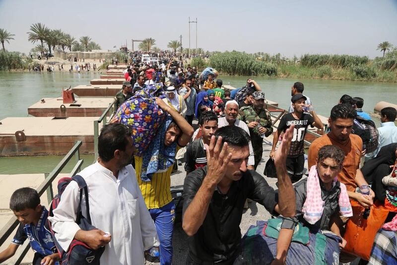 Iraqis from Ramadi cross the Bzebiz bridge in a bid to flee fighting in the Iraqi city 65km west of Baghdad as ISIL takes control. Karim Kadim/AP Photo