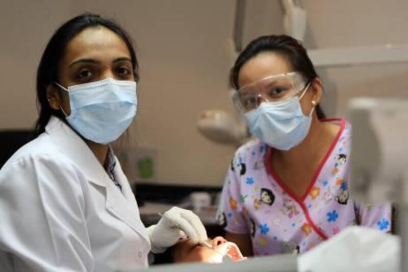 ABU DHABI - 02NOV2011 - Dr. Bhagyashree Aditya Namjoshi (L) dental Surgeon treating a patient at Taj Dental centre in Abu Dhabi. Ravindranath K / The National