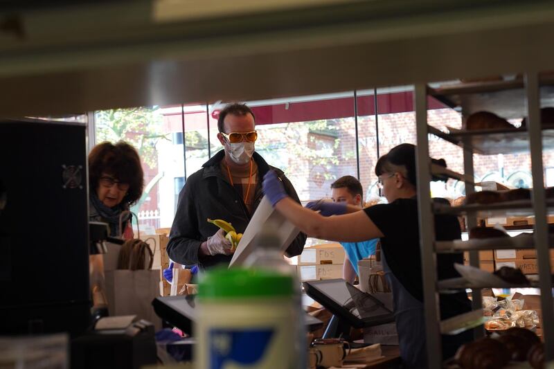 LONDON, ENGLAND - APRIL 16: A member of staff serves a customer at Gail's bakery-and-cafe in Salusbury Road, Queen's Park who are donating baked goods to NHS Workers on April 16, 2020 in London, England. During the COVID-19 outbreak and lockdown, the bakery-and-cafe chain says it is providing 2400 meals per week to hospitals in neighborhoods near some of its 50 London stores. It also continues to operate a home delivery business and allows takeaway orders at some locations. (Photo by Mark Case/Getty Images)