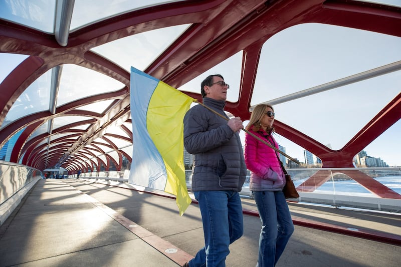 Supporters of Ukrainian sovereignty arrive with a Ukrainian flag before holding a protest on the Peace Bridge in Calgary,  Canada. Reuters