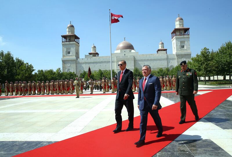 Jordan's King Abdullah II, centre, walks with Turkey's President Recep Tayyip Erdogan, left, during a welcome ceremony at the Jordanian Royal Palace in Amman, Jordan. Erdogan is in Jordan on a one-day official visit. (Pool Photo via AP)