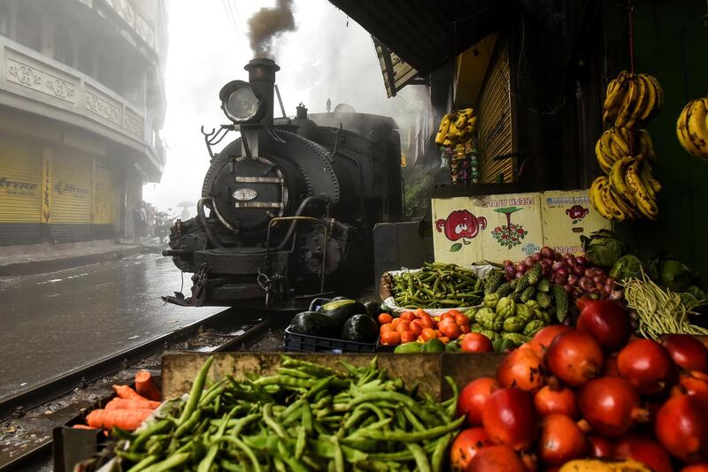 A Darjeeling Himalayan Railway steam train passes by a market in Ghum, India. All photos by Reuters