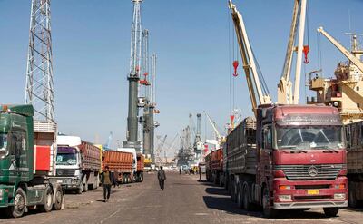 This picture taken on March 14, 2021 shows a view of trucks parked along ships on a pier at the port of Umm Qasr, south of Iraq's southern city of Basra. Iraq is ranked the 21st most corrupt country by Transparency International. In January, the advocacy group said public corruption had deprived Iraqis of basic rights and services, including water, health care, electricity and jobs. It said systemic graft was eating away at Iraqis' hopes for the future, pushing growing numbers to try to emigrate. In 2019, hundreds of thousands of protesters flooded Iraqi cities, first railing against poor public services, then explicitly accusing politicians of plundering resources meant for the people. / AFP / Hussein FALEH
