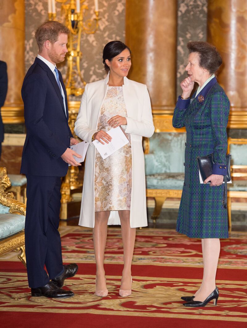 Prince Harry, Meghan, Duchess of Sussex, and Princess Anne attend a reception to mark the 50th anniversary of the investiture of the Prince of Wales at Buckingham Palace in 2019.