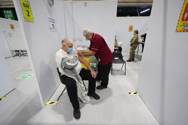Robert Ward, 56, a retired nurse from Blackpool Victoria Hospital, injects a patient with a dose of the Oxford/AstraZeneca vaccine during a clinic at the Winter Gardens in Blackpool. AFP