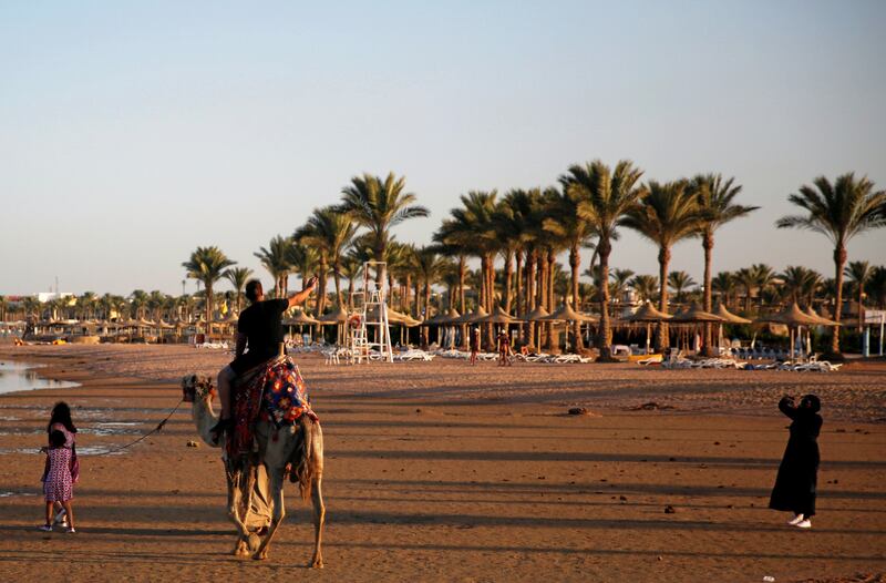 9. Tourists take a picture with a camel on a beach facing the Gulf of Aqaba, in the Red Sea resort of Sharm El-Sheikh,  Egypt. Reuters