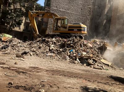 A bulldozer removes the debris from a building that collapsed in Cairo's El-Weili neighborhood in June, 2022. AP
