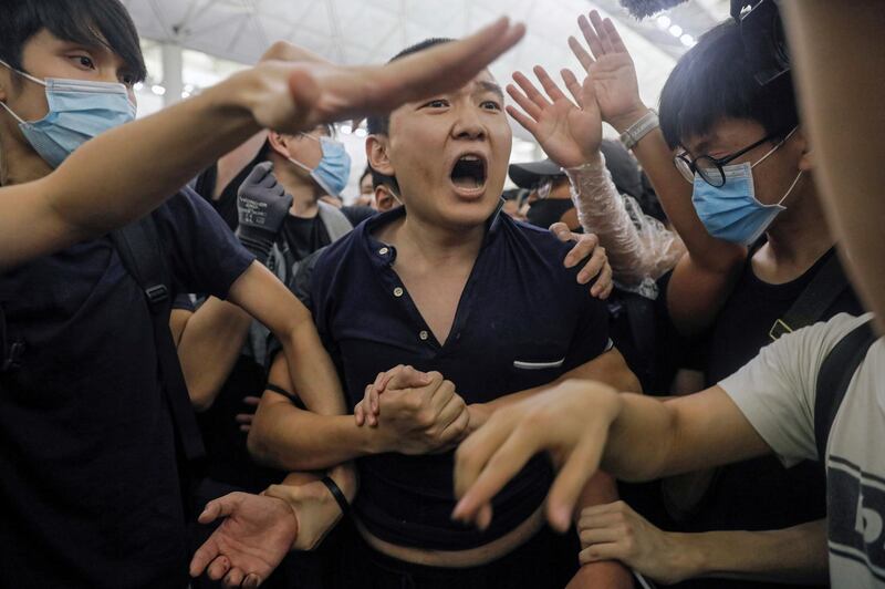 Protesters detain a man, who they claimed was a Chinese undercover agent during a demonstration at the airport in Hong Kong. AP Photo