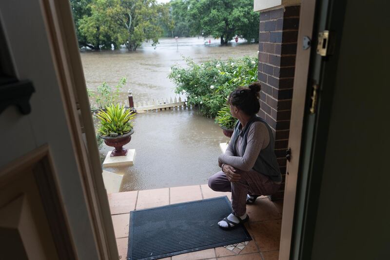 Windsor resident Kelly Miller shows concern as flood waters reach her workplace, a 100 year old property near the Windsor CBD in Sydney. Getty Images