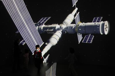 A child stands near a giant screen showing the images of the Tianhe space station at an exhibition featuring the development of China's space exploration on the country's Space Day at China Science and Technology Museum in Beijing, China April 24, 2021. REUTERS/Tingshu Wang