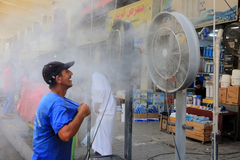 An Iraqi man cool himself off in a spray of water during a sweltering hot day at the Al-Khilani square in central Baghdad, Iraq. EPA 