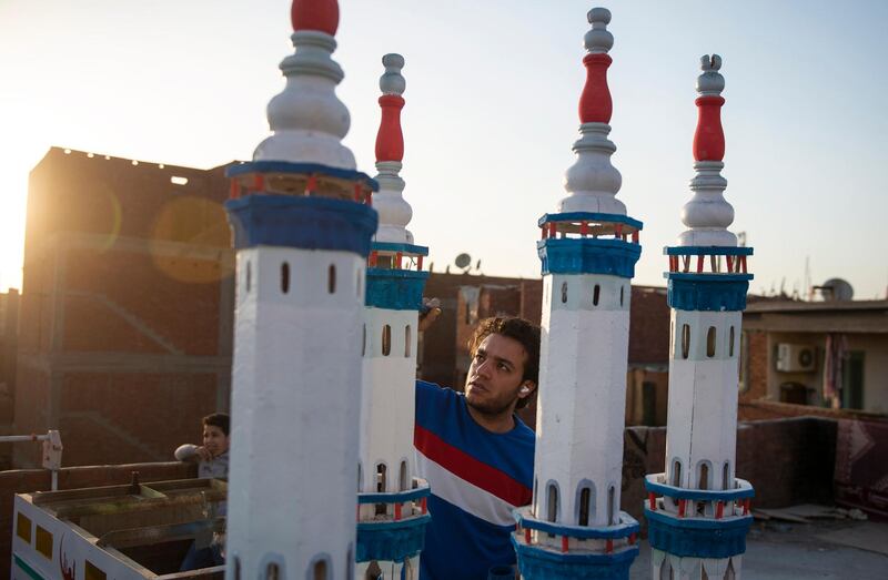 A man paints wooden minarets as a Ramadan decoration in Cairo. EPA
