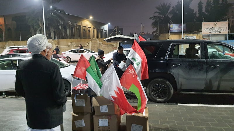 A street vendor sells flags of participating countries at Basra Corniche