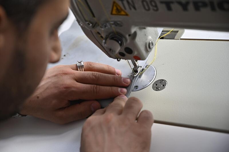 Syrian tailor Khaldoun Alhussain works on July 12, 2019 at the workshop of the small Berlin company Mimycri. AFP